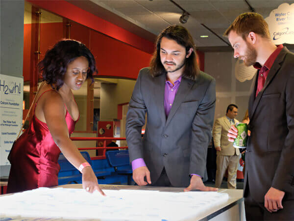 Young adults in fancy dress using interactive exhibit table