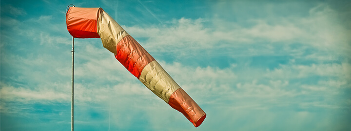 A wind sock with dark clouds in the background.