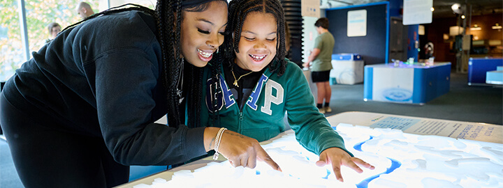 Mother and child interacting with a water table