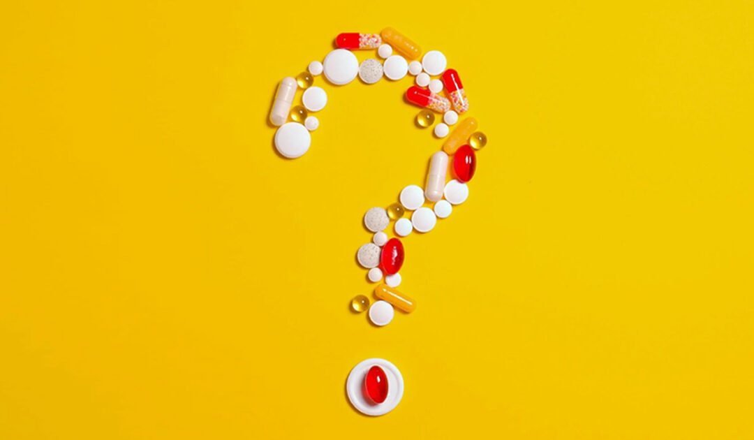 Vitamin pills forming a question mark