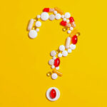 Vitamin pills forming a question mark