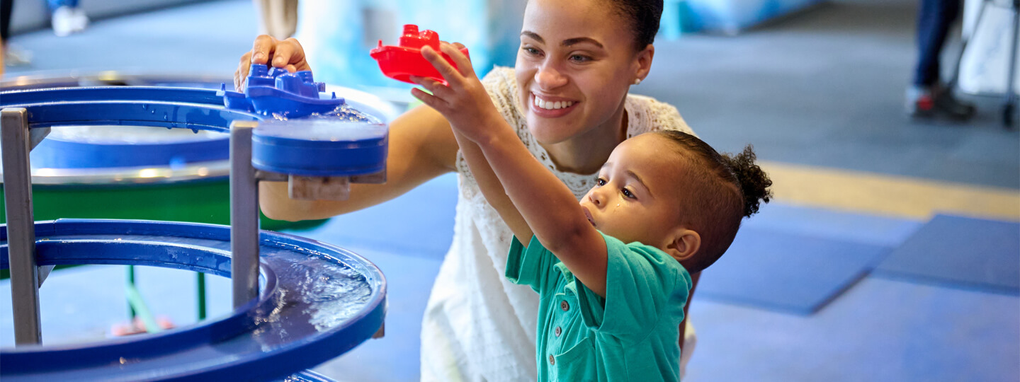 Mother and child playing at a water table