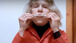Woman holding popsicle sticks to her mouth