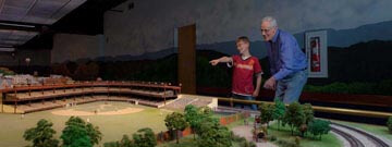 Boy pointing at trains with Grandfather