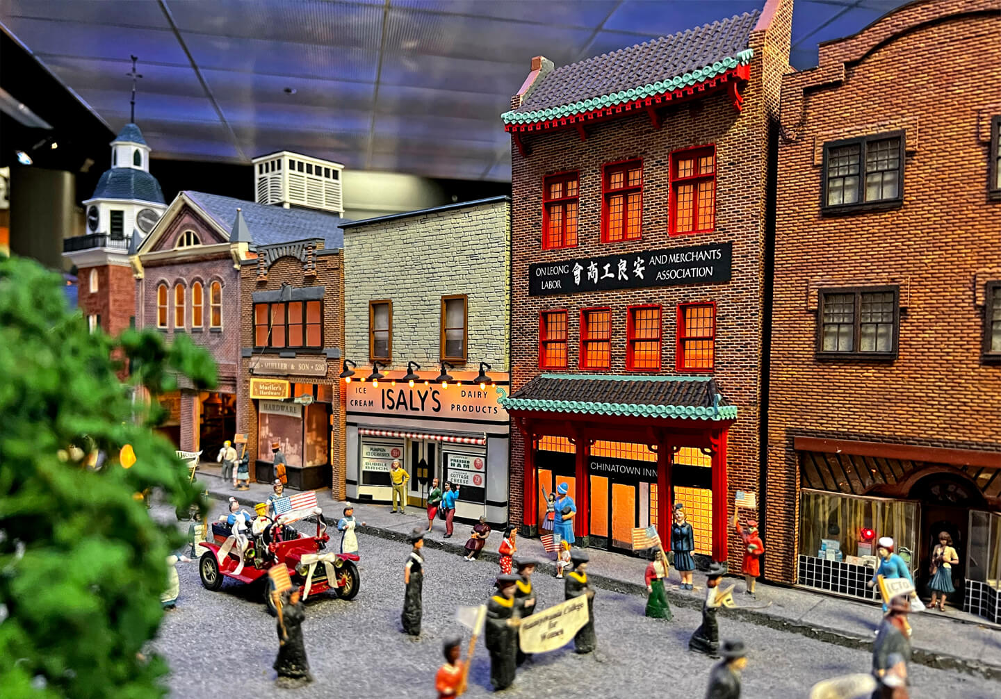 Miniature model of the Chinatown Inn with a parade of miniature people going down a street