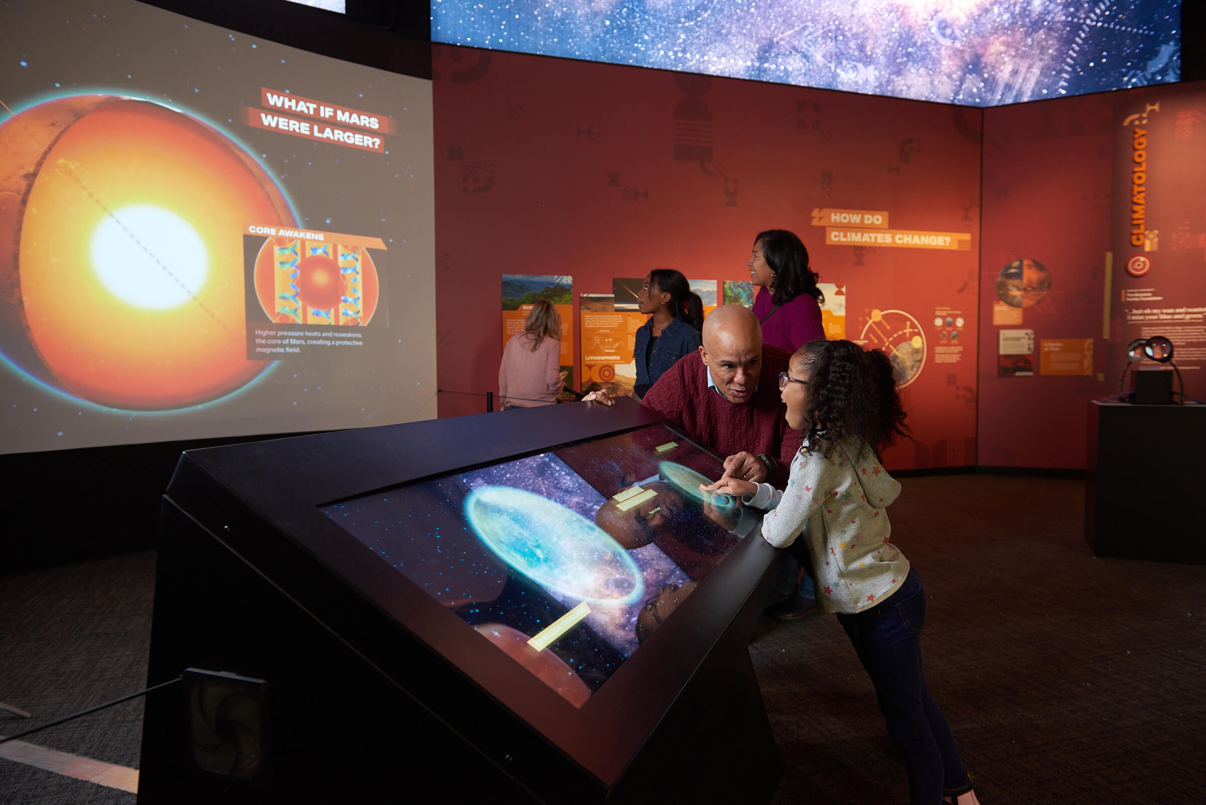 Man and child interacting with a touchscreen for Mars