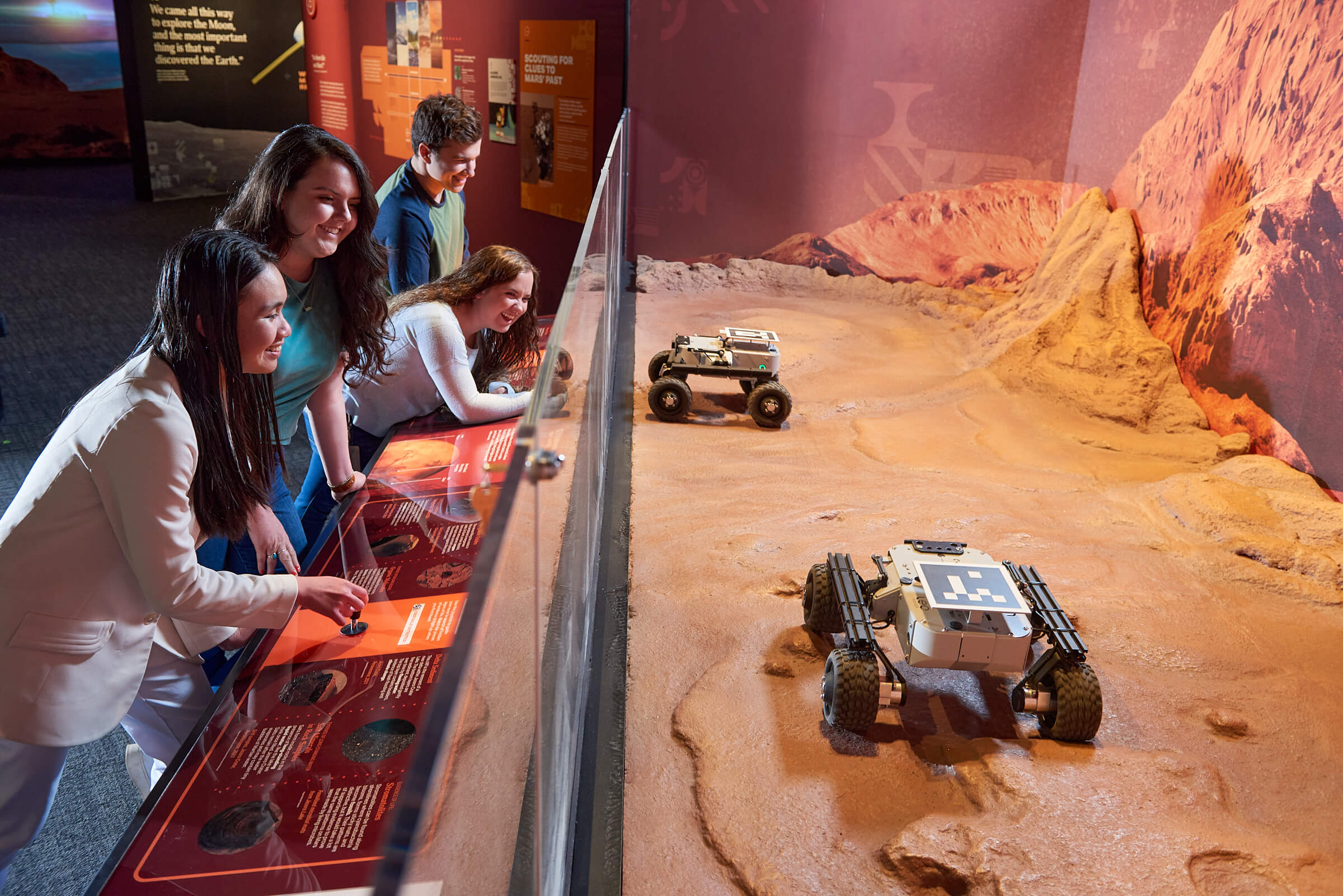 A group of teens controlling small Mars rovers