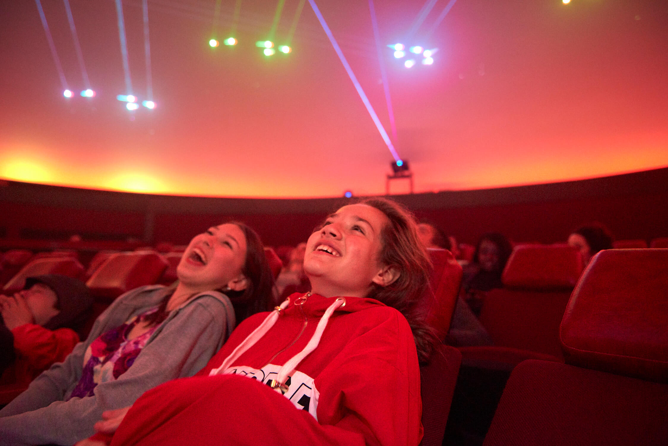 Two girls laughing, sitting in the Buhl Planetarium