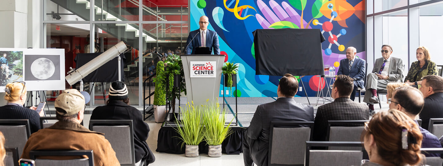 Science Center Director addresses a crowd at a press conference