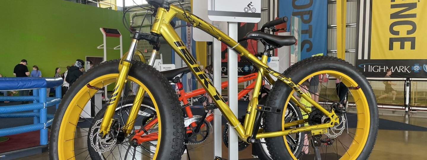 A yellow Fat Bike bicycle displayed in Highmark SportsWorks.