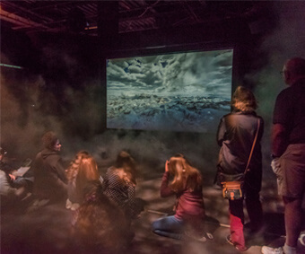 A group of people watching a movie surrounded by fog