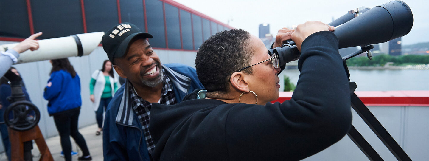 Man with woman looking through binoculars