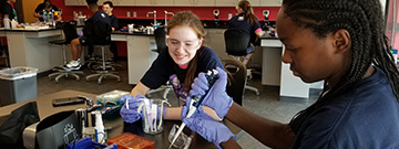students wearing goggles working in a lab